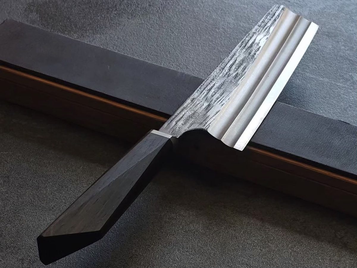 Nakiri with textured blade and dark faceted wooden handle